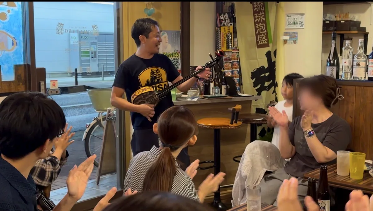 三線を弾きながら歌うお店のスタッフと、手拍子で盛り上がるお客さん
